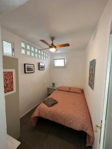 um quarto com uma cama e uma ventoinha de tecto em Apartment in old town with roof terrace and fibre, Tarifa em Tarifa