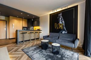 un salon avec un canapé et une table dans l'établissement LupoApartments Premium z Klimatyzacją, Wanną w Sypialni Manufaktura Parking Dostęp na Kod, à Łódź