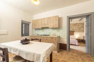 une cuisine et une salle à manger avec une table et une chambre dans l'établissement Antico Forno Baunei, à Baunei