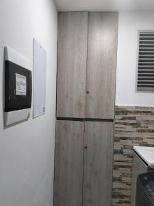 a kitchen with a wooden cabinet and a refrigerator at Habitación en Cartagena in Cartagena de Indias