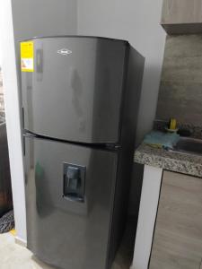 a stainless steel refrigerator in a kitchen next to a counter at Habitación en Cartagena in Cartagena de Indias