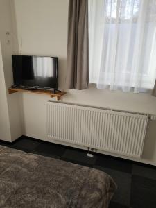 a flat screen tv sitting on a radiator under a window at Blatterlhof 