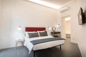 a white bedroom with a large bed and a television at Your Vatican Suite in Rome
