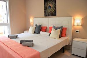 a bedroom with a large white bed with colorful pillows at CASA AVVA in San Miguel de Abona +38 photos