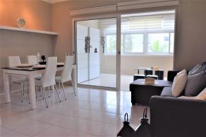 a living room with a table and white chairs at CASA AVVA in San Miguel de Abona