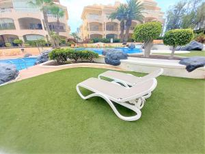 a white lounge chair on the grass near a pool at CASA AVVA in San Miguel de Abona