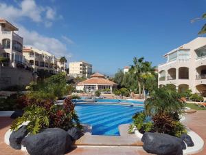 a swimming pool at a resort with trees and buildings at CASA AVVA in San Miguel de Abona