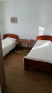 a room with two beds and a table in it at Villa Teodora in Donja Vrućica