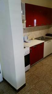 a kitchen with a white stove and red cabinets at Villa Teodora in Donja Vrućica