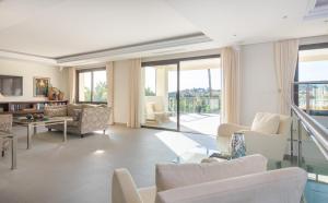 a living room with white furniture and sliding glass doors at 5 bed-villa with golf court view in Marbella