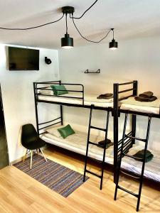 オシフィエンチムにあるOld Tree Home & Restaurantの二段ベッド3台と椅子が備わる客室です。