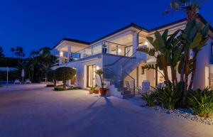 een groot wit huis met palmbomen ervoor bij 5 bed-villa with golf court view in Marbella