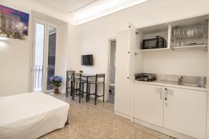 Una cocina con gabinetes blancos y una cama en una habitación. en Your Vatican Suite, en Roma