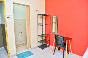 uma casa de banho com uma parede vermelha, uma mesa e um chuveiro em T FAMILY HOTEL em Klang