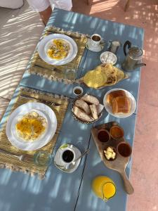 une table bleue avec des assiettes de nourriture pour le petit-déjeuner dans l'établissement Dar Malwan, à Marrakech