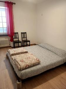 - une chambre avec un lit, 2 chaises et une fenêtre dans l'établissement La Fiorita, à Bironico