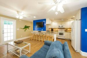 uma sala de estar com um sofá azul e uma cozinha em Just steps to Duval- Sleeps 10- Heated Pool House em Key West