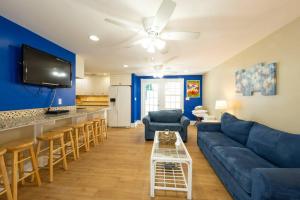 a living room with a blue couch and a bar at Just steps to Duval- Sleeps 10- Heated Pool House in Key West