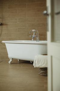 a white bath tub with a faucet in a bathroom at Contryside holiday house, for even better energy sourcing in Detva