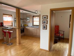 a kitchen with wooden floors and red chairs in a room at Ferienwohnung Meridiana in Tuntenhausen