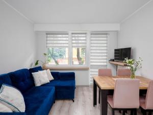 a living room with a blue couch and a table at Best Choice 2-bedroom Apartment in Płock