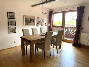 a dining room with a wooden table and chairs at Ferienwohnung Meridiana in Tuntenhausen