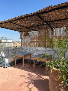 d'un canapé et d'une table sur une terrasse. dans l'établissement Dar Malwan, à Marrakech