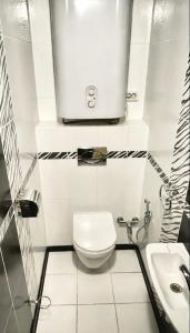 La salle de bains blanche est pourvue de toilettes et d'un lavabo. dans l'établissement Zoryaniy Apartments City ПРОСТОРА та затишна НОВОБУДОВА біля парку Шевченка та ЦЕНТРУ, à Tchernivtsi
