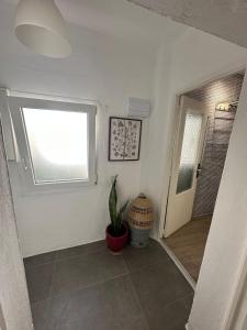 a hallway with a window and a potted plant at Apartment in old town with roof terrace and fibre, Tarifa in Tarifa