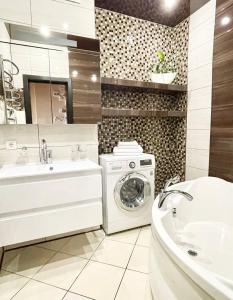 a bathroom with a washing machine and a sink at Zoryaniy Apartments City ПРОСТОРА та затишна НОВОБУДОВА біля парку Шевченка та ЦЕНТРУ in Chernivtsi