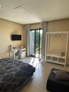 a bedroom with a bed and a desk and a television at Etna Petit Relais in Nicolosi +58 photos