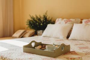 bandeja de madera con tazas y galletas en la cama en Contryside holiday house, for even better energy sourcing, en Detva