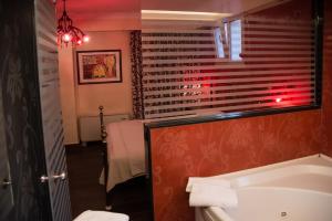 a bathroom with a white toilet and a red wall at Hotel Maroussi in Athens