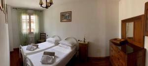 a bedroom with two beds and a dresser at Apartment-Rosella Garda in Garda