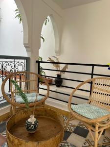 two chairs and a potted plant on a porch at Dar Malwan in Marrakech