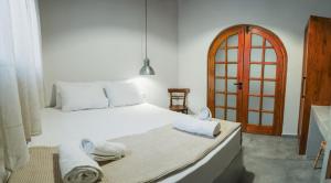 アルハンゲロスにあるAesthisis Sensational Accommodation Archangelosのベッドルーム1室(白いベッド1台、タオル付)