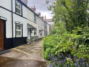 a row of houses with purple flowers on a street at 4 Railway Terrace in Conwy