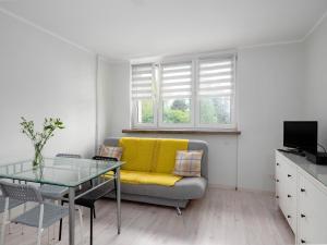 uma sala de estar com um sofá amarelo e uma mesa de vidro em Sweet Honey Mieszkanie w Płocku em Plock