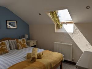 een slaapkamer met een bed en een raam bij Barton Cottage in Bridport
