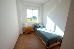 een kleine slaapkamer met een bed en een raam bij Casa La Marina spacious apartment 100m in La Marina
