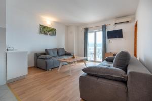 a living room with two couches and a table at Apartments IN in Neum