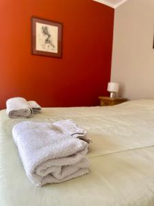 uma pilha de toalhas sentadas em cima de uma cama em POSTA 20 - Cálido apartamento temporario! em Salta