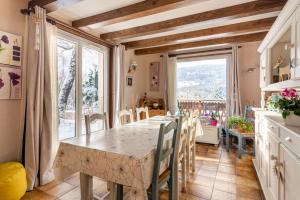 uma cozinha com uma mesa e uma grande janela em Appartement Entre Lacs Et Montagnes em Habère-Lullin