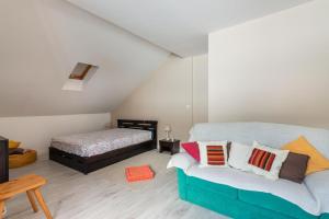 um quarto com uma cama e um sofá com almofadas em Appartement Entre Lacs Et Montagnes em Habère-Lullin
