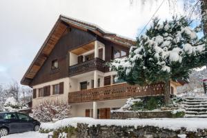 une maison dans la neige avec une voiture garée devant dans l'établissement Appartement Entre Lacs Et Montagnes, à Habère-Lullin