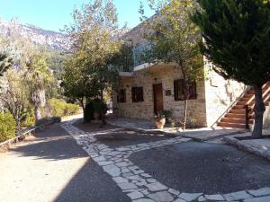 Casa de piedra con entrada de piedra en Akros Oreon Apartment Voliares, en Káto Sími