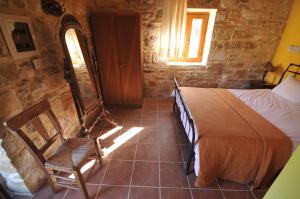 um quarto com uma cama, uma cadeira e uma janela em Akros Oreon Junior Suite Amori em Káto Sími