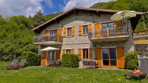 une grande maison avec des chaises et un parasol dans l'établissement Casa Paola, à Vesta