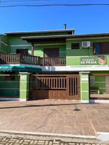 un bâtiment vert avec un panneau sur lui dans l'établissement Pousada da Praia Imbé, à Imbé