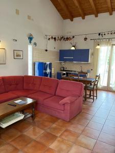 a living room with a red couch and a kitchen at Apartment-Rosella Garda in Garda